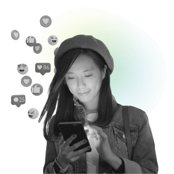 Social media a woman looking at her phone and smiling. A trail of hearts, smily faces and thumbs up streams from the phone screen into the air around her, indicating her social media marketing efforts are working.